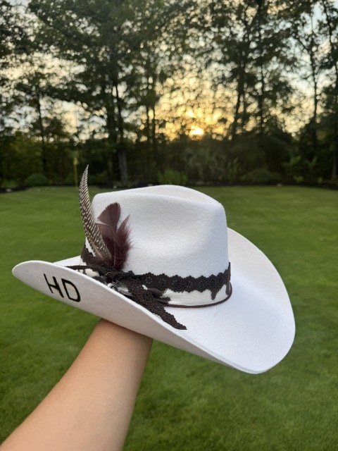 A tan hat with cream and orange band, styled with an orange dress