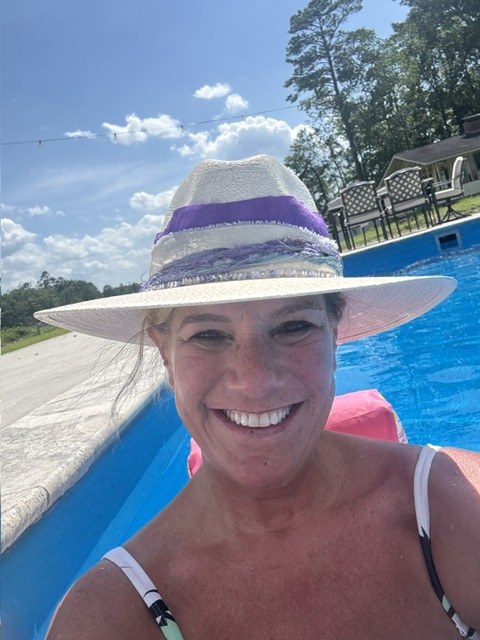 A cream hat with a lavender band, worn poolside